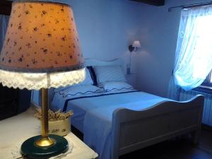ein Schlafzimmer mit einem Bett und einer Lampe auf einem Tisch in der Unterkunft Dimora Toscana in Seggiano