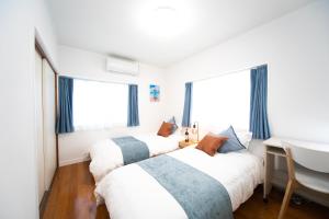 桑名市にあるNagashima Riverside Resort 1の窓が2つある部屋にベッドが2つある