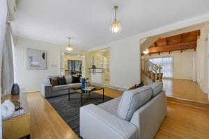 uma sala de estar com um sofá e uma mesa em 12 mins to Mel Airport-Good Wood House em St Albans