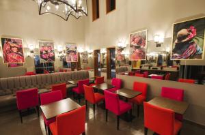 a restaurant with red chairs and tables in a room at Atiq Boutique Hotel in Cusco