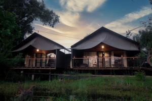 a building with a tent in a field at Leopard Trails Yala in Yala
