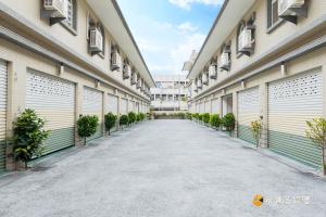 une allée vide entre deux bâtiments avec des portes de garage dans l'établissement Fu Bao Motel, à Hualien