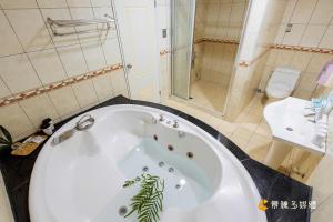 a bathroom with a large white tub and a toilet at Fu Bao Motel in Hualien City +38 photos