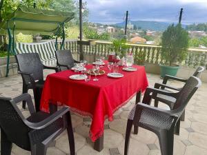 une table avec un tissu de table rouge sur une terrasse dans l'établissement Hotel 9th Sky, à Koutaïssi