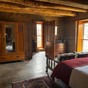 - une chambre avec un lit, une commode et un miroir dans l'établissement Klipkraal Farm, à Calitzdorp