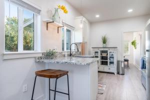 a kitchen with white walls and a counter with stools at Fresh bungalow next to UArizona! in Tucson