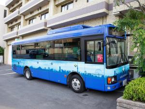 niebieski autobus zaparkowany przed budynkiem w obiekcie FLEXSTAY INN Shinurayasu w mieście Urayasu