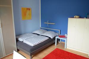 een slaapkamer met een bed met een blauwe muur bij Quartier Ostheim in Keulen