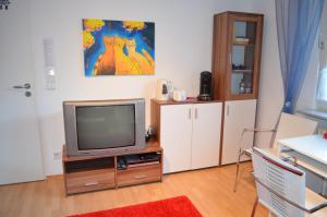 sala de estar con TV en un soporte de madera en Quartier Ostheim, en Colonia