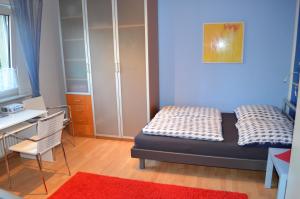 a small bedroom with a bed and a desk at Quartier Ostheim in Cologne