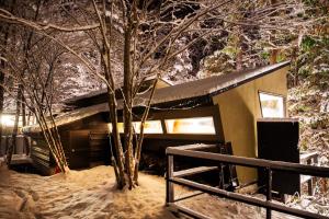 a house in the snow next to a tree at Sumiya Rakusuitei - Vacation STAY 16647v in Takayama