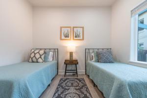 two beds sitting next to each other in a room at Fresh bungalow next to UArizona! in Tucson
