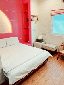 a bedroom with a white bed and a pink wall at Jinye B&B 金夜民宿 in Xiaoliuqiu +9 photos