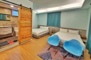 a bedroom with two beds and a table and two chairs at A Promised Land BnB in Jiufen