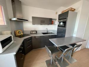 a kitchen with a table and some chairs in it at Appartement Capbreton, 2 pièces, 4 personnes - FR-1-413-101 in Capbreton