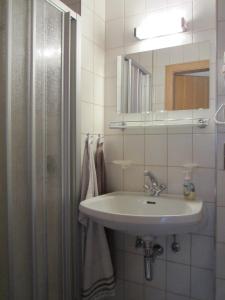 y baño con lavabo y ducha con espejo. en Gästehaus Holzfeind, en Hermagor