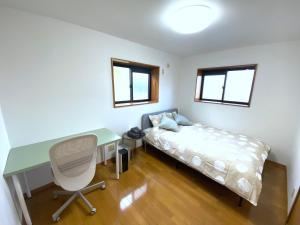 a bedroom with a desk and a bed and a desk and a chair at Bleu Celeste Kazuyama in Numazu