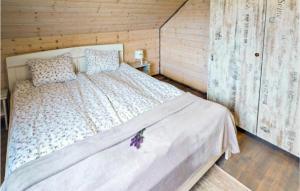 a bedroom with a bed in a wooden cabin at Awesome Home In Karwia With Outdoor Swimming Pool in Karwia