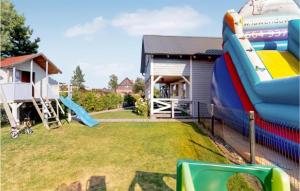 a playground with a slide next to a house at Awesome Home In Karwia With Outdoor Swimming Pool in Karwia