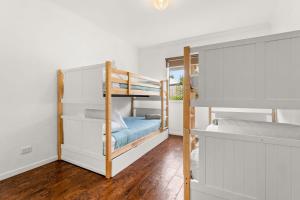 a bedroom with two bunk beds and a mirror at Shallow Water Retreat in Cowes