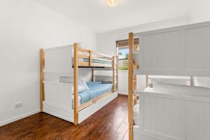 a bedroom with two bunk beds and a mirror at Shallow Water Retreat in Cowes