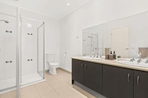 a bathroom with two sinks and a shower and a toilet at Shallow Water Retreat in Cowes +11 photos