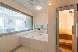 een badkamer met een bad en een wastafel bij Samson Hotel in Hirado