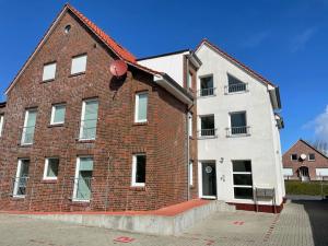 a red brick building with a white house at Mühlenstraße 19 Ferienwohnung 50227 in Carolinensiel +14 photos