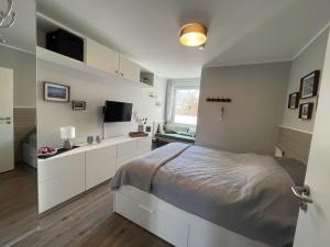a bedroom with a bed and a television in it at Mühlenstraße 19 Ferienwohnung 50227 in Carolinensiel
