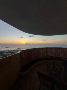 einen Balkon mit Blick auf das Meer und den Sonnenuntergang in der Unterkunft apartment with sea view- itallian jaccuzi in Netanya