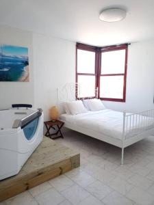Dieses weiße Zimmer verfügt über ein Bett und eine Badewanne. in der Unterkunft apartment with sea view- itallian jaccuzi in Netanya