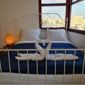 ein Bett mit zwei Handtüchern in Herzform in der Unterkunft apartment with sea view- itallian jaccuzi in Netanya