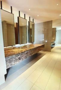 Baño con una fila de lavabos y espejos en Almas Suites 무지 바다 전망 넷플릭스, 스텔라 국제학교까지 도보 2분 STAY, en Nusajaya