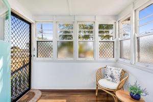una camera con finestre, una sedia e un tavolo di Cheerful, Cosy Cottage - Near Rose Garden! a Toowoomba Altre 7 foto