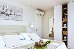 a white bedroom with a bed with white pillows at Villa Luxury Dream, Indoor Heated Pool, 7 persons, Sea Views, Omiš in Omiš