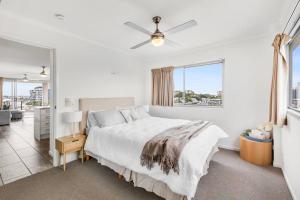 een witte slaapkamer met een bed en een raam bij Spacious Inner city Apartment in Brisbane