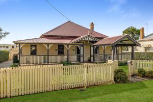 a house with a fence in front of it at Elegant, Stunning & Central! East Side Gem! in Toowoomba