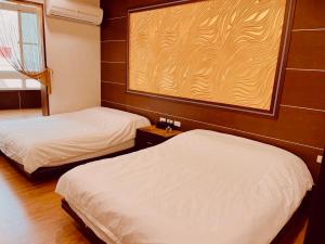 a room with two beds in a room with a window at Jinye B&B 金夜民宿 in Xiaoliuqiu