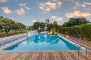 a large swimming pool with a wooden deck at Seven Corbett in Rāmnagar