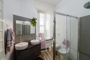 un bagno con due lavandini e una doccia in vetro di Your Dream on Lake Maggiore: Historic House e Private Jacuzzi a Stresa