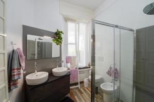 uma casa de banho com 2 lavatórios e uma cabina de duche em vidro. em Your Dream on Lake Maggiore: Historic House e Private Jacuzzi em Stresa