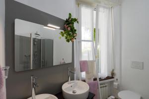 un bagno con due lavandini, uno specchio e una finestra di Your Dream on Lake Maggiore: Historic House e Private Jacuzzi a Stresa