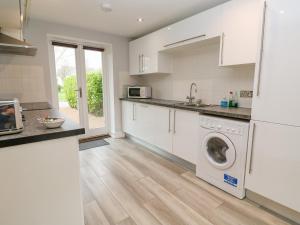 a kitchen with a washer and dryer at 19 Bay Retreat Villas in St Merryn