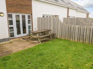 a picnic table in a yard next to a fence at 19 Bay Retreat Villas in St Merryn
