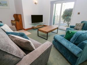 a living room with two couches and a tv at 9 Beachcombers Apartments in Newquay