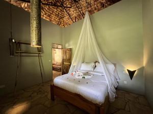 a bedroom with a bed with a mosquito net at The Jungle Pearl Resort in Mto wa Mbu