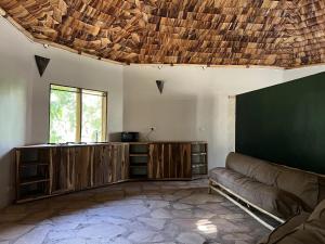 uma sala de estar com um sofá e um grande ecrã em The Jungle Pearl Resort em Mto wa Mbu