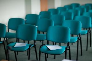 a room filled with blue chairs with papers on them at Hotel Albatros in Przemyśl