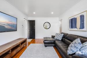 a living room with a brown leather couch at Eastside Haven - Central & Convenient! in Toowoomba