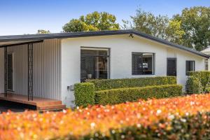 a white house with a garden in front of it at Eastside Haven - Central & Convenient! in Toowoomba